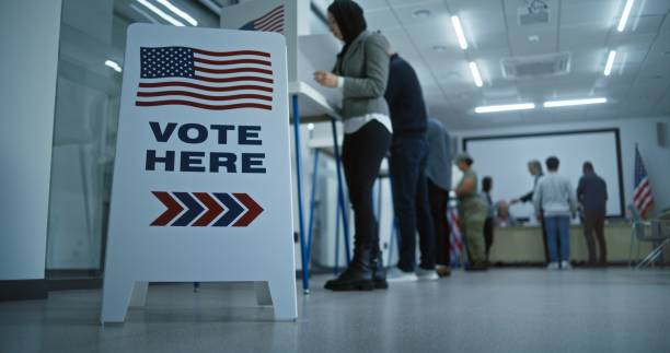 istock Vote here sign on the floor in polling station office 2149118425