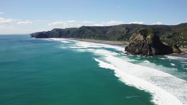 Looking along the rugged coastline Piha Beach, at the famous outcrop known as Lion Rock, in New Zealand.