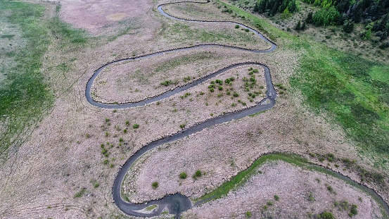 Aerial photo of a winding stream making it's way out of the Rocky Mountains.