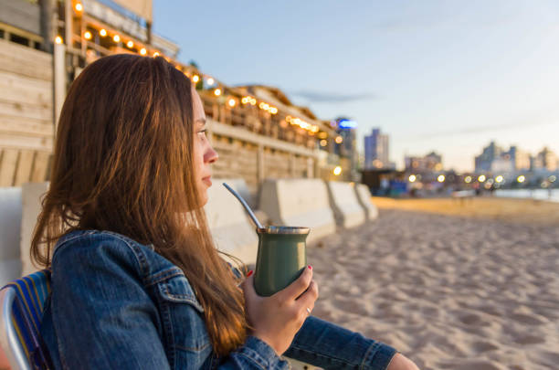 istock Beautiful young woman drinking mate (chimarao) 2149121140