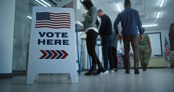 istock Vote here sign on the floor in polling station office 2149121372
