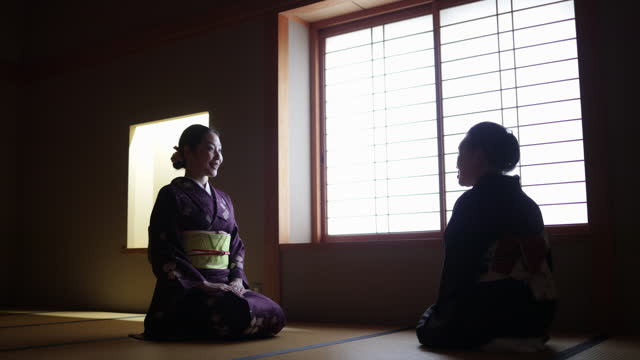 Female tourist in purple kimono learning manners of greetings from a senior instructor in dark Japanese tatami room - part 4 of 4