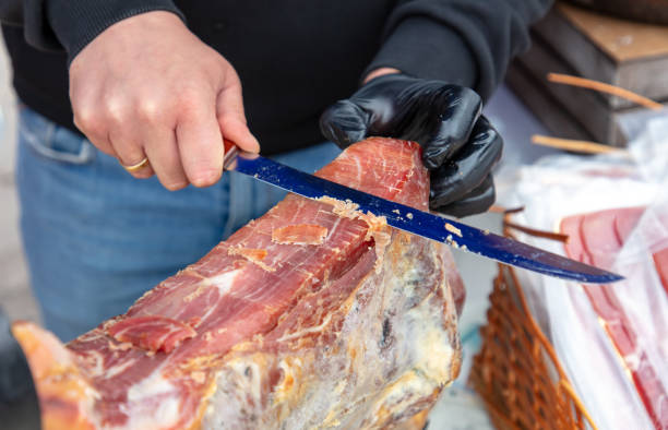 istock Man cut off meat jamon with a knife 2149123123