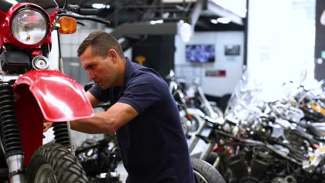 Focused mechanic working on a motorbike at a repair garage