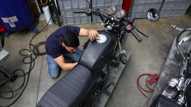 High angle view of mechanic fixing a motorbike at a repair garage