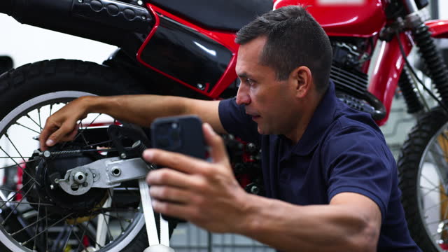 Motorbike mechanic showing something to the owner through a video call