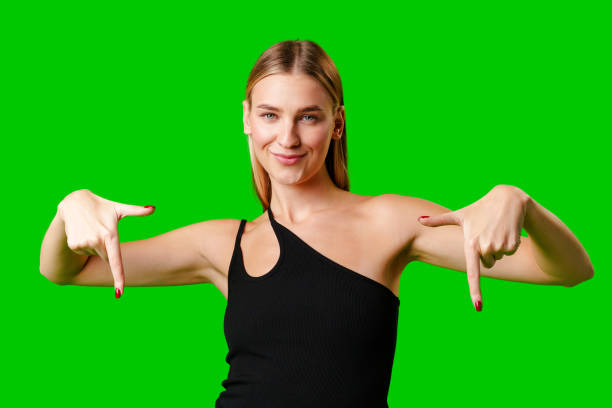 istock Young Woman Pointing at Something against green background 2149124756
