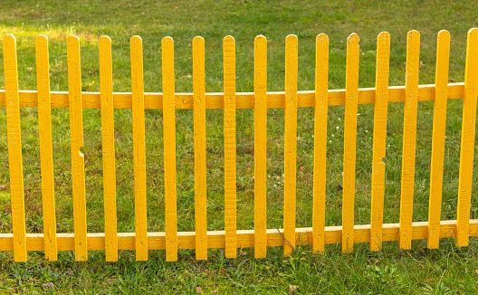 Yellow wooden fence in nature. Background.