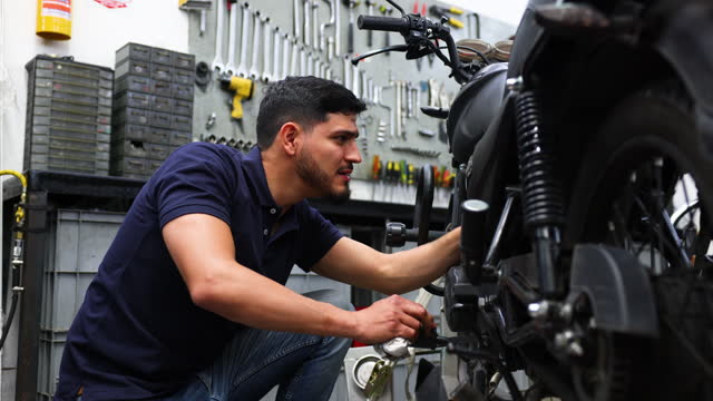 Mechanic repairing a motorcycle at a garage