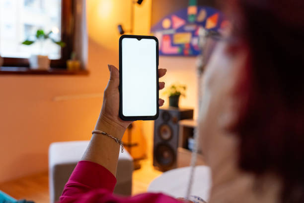 istock Senior woman using phone in living room 2149127101