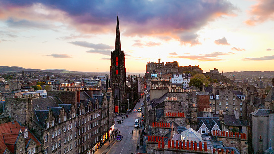 Aerial view of Edinburgh old town at sunset with Tolbooth Kirk Church, sunset aerial view of the Old Town and Royal Mile in Edinburgh, The Hub high tower church in Edinburgh city centre, Gothic Revival architecture in Scotland