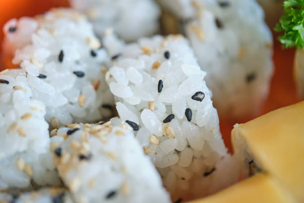 Closeup of traditional sushi rolls with rice sesame seeds and sprig of fresh parsley