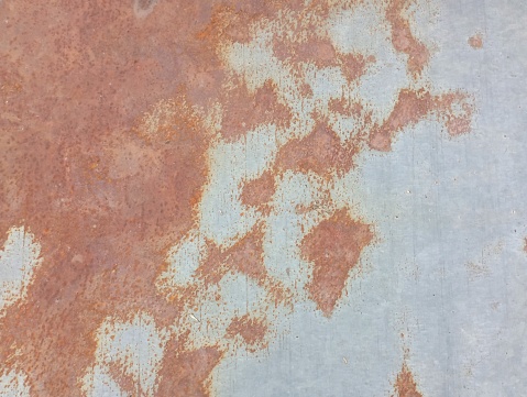 Rust stains on the metal. The texture of rusty metal with spots on the surface of a galvanized sheet.