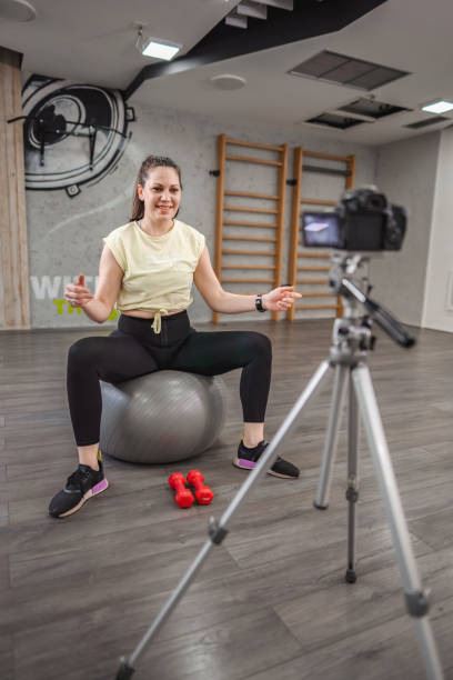 istock Woman filming a tutorial about working out with weights at the fitness studio 2149129266