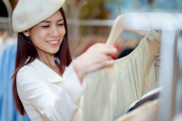 Portrait of young happy smiling woman with shopping bags, over gray background