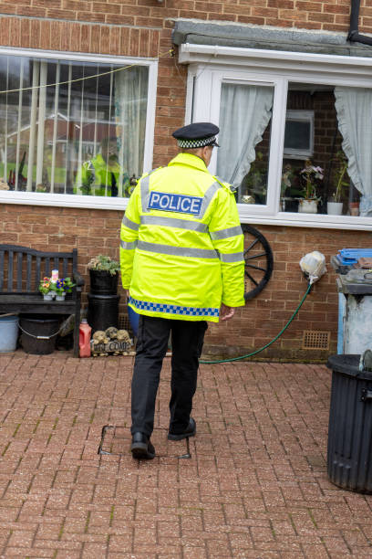 istock A policeman walking towards an elderly person's home. 2149131119
