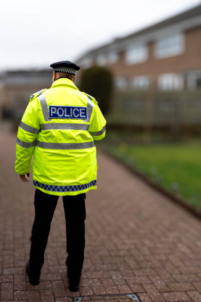 istock A policeman walking away from an elderly person's home. 2149131232