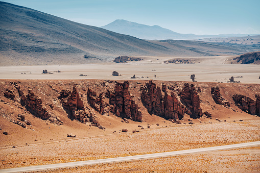 Stunning view of rocky cliffs and expansive desert in the Atacama Desert, Chile, showcasing arid landscapes under a clear blue sky.