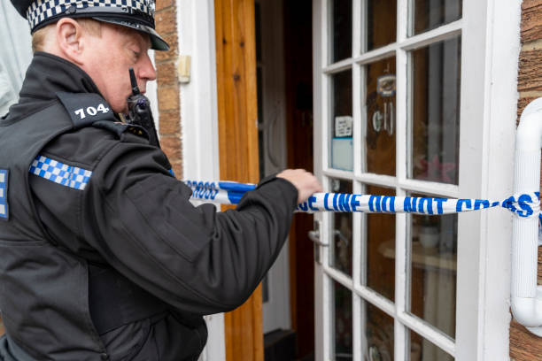 istock A policeman putting barricade tape across an elderly person's doorway. 2149131690