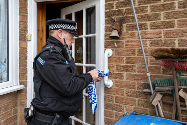istock A policeman putting barricade tape across an elderly person's doorway. 2149131697