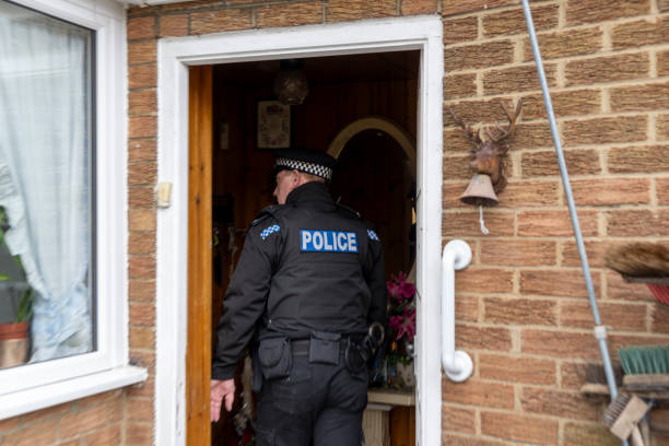 A policeman entering an elderly person's home.