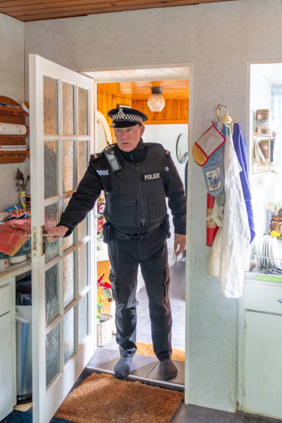 istock A policeman entering an elderly person's home. 2149131865