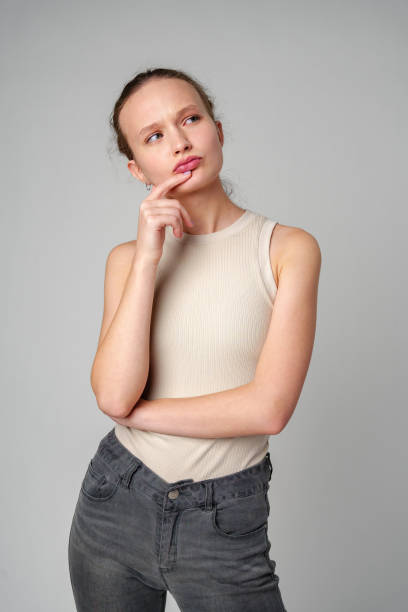 istock Young Woman Posing deep in thought on gray background 2149132279