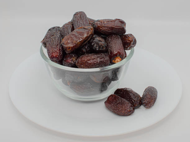 safawi dates in the glass bowl with white background Safawi dates are high in fiber and potassium, which can help improve digestion and overall health.Safawi dates are a special variety of dates mainly grown in Saudi Arabia in the Al-Madina region dátiles safawi en el cuenco de cristal con fondo blanco los dátiles safawi tienen un alto contenido de fibra y potasio, lo que puede ayudar a mejorar la digestión y la salud en general. los dátiles safawi son una variedad especial de dátiles que se cu
