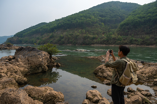 The man taking photos between the reef and the river