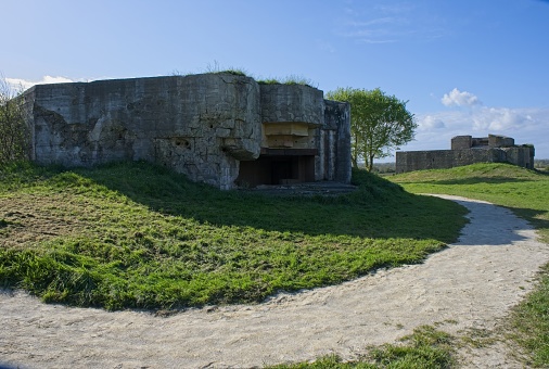 Panoramic view of the perimeter walls of a disused magazine fort in Phoenix Park, Dublin, on a bright sunny day with green grassy slopes and crumbling bricks