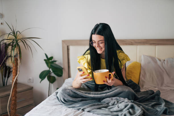 istock A young woman is having breakfast in bed and using her smartphone. 2149135261
