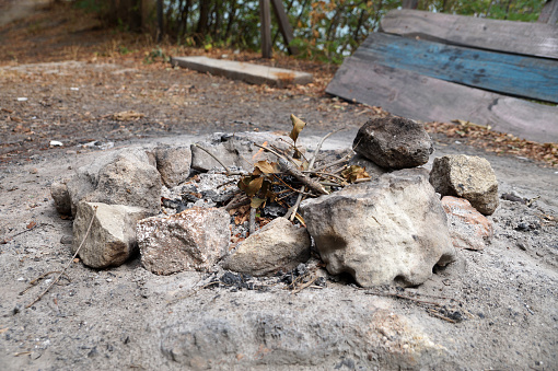 remnants of a campfire circled by stones outdoors.
