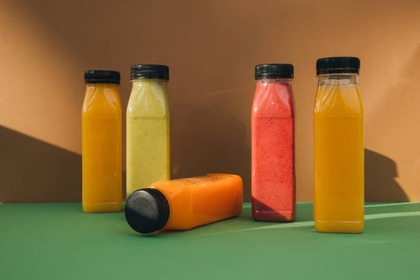 istock Fruit and vegetable smoothies in transparent plastic bottles. Red, green, orange smoothies on a brown-green background 2149137084