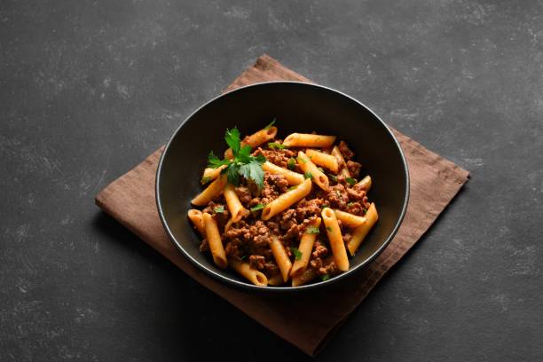 istock Penne pasta with minced meat, tomato sauce and greens 2149137184