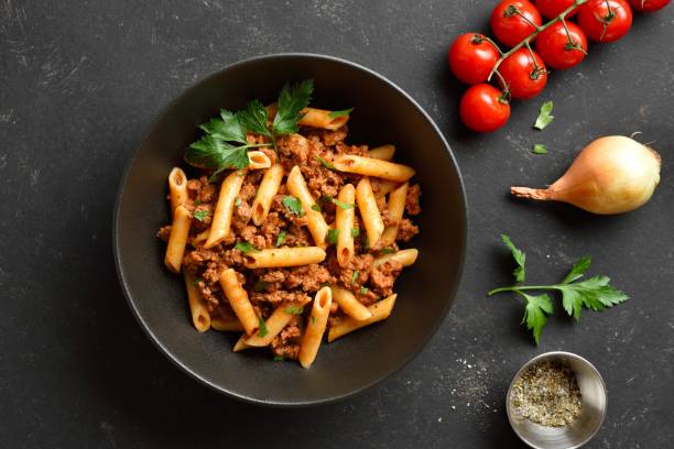 istock Penne pasta with minced meat, tomato sauce and greens. Top view, flat lay 2149137189