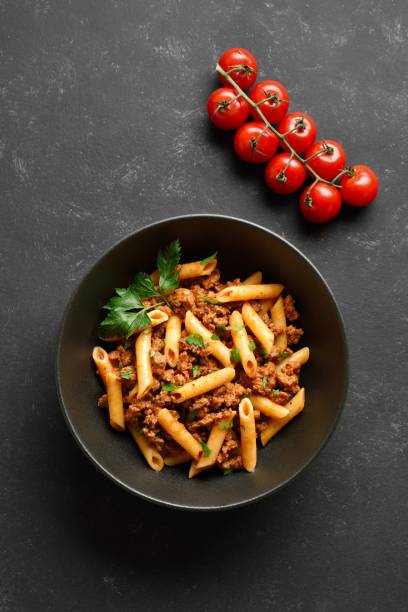 istock Penne pasta with minced meat, tomato sauce and greens. Top view, flat lay 2149137190