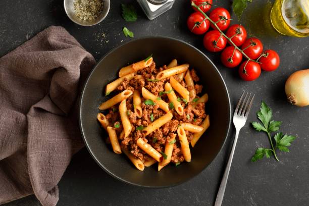 istock Penne pasta with minced meat, tomato sauce and greens 2149137195