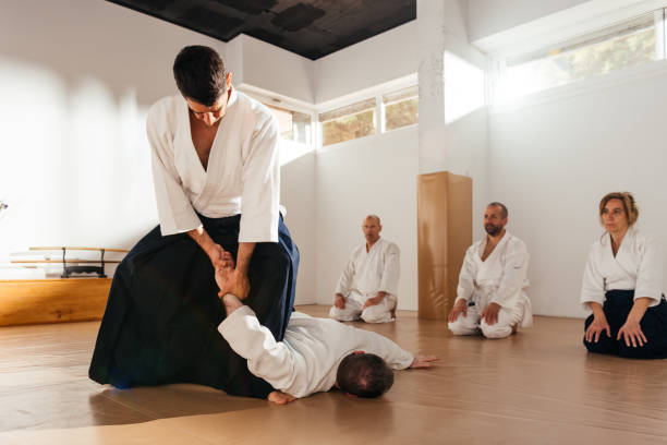 istock Martial Arts Sensei Demonstrating Wrist Lock Technique to Students in Dojo 2149138845