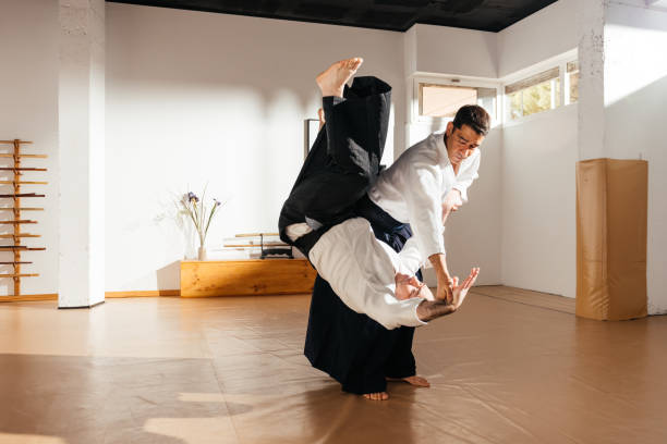 Martial Artist Executing a Controlled Throw on Partner in Dojo
