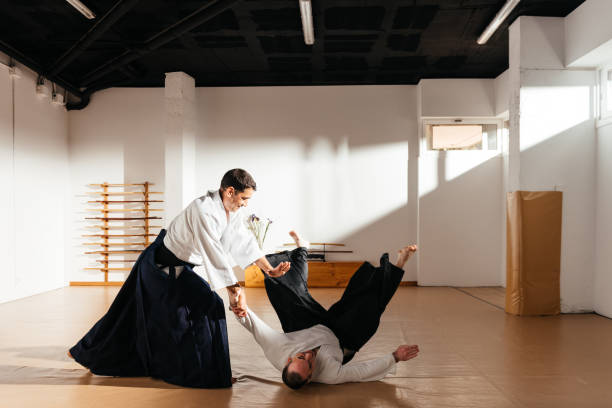 istock Martial Artist Demonstrates Throwing Technique in Traditional Dojo Setting at Daytime 2149139234