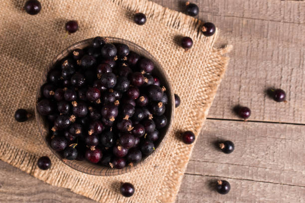 istock Black currant in a bowl on wooden background. Organic berries. 2149140541