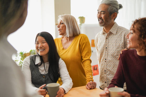 istock Group of multiracial people having fun drinking coffee together inide home kitchen - Diverse coworker colleagues doing tea break - Focus on asian man face 2149141515