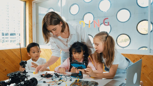 istock Teacher looking at children while diverse student looking at screen. Erudition. 2149142617