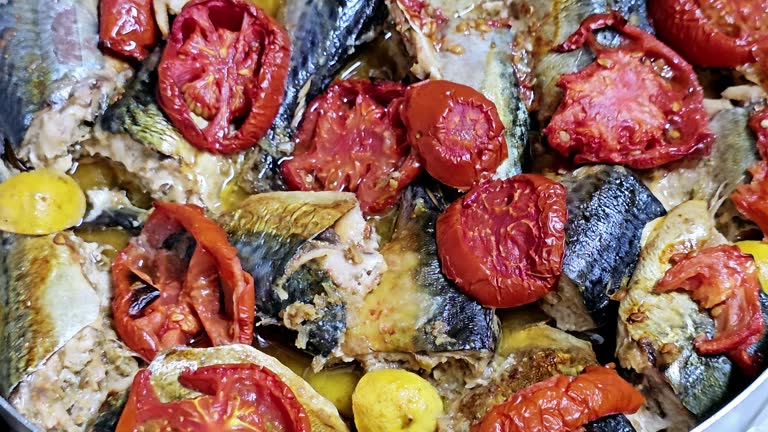 Mackerel fish, baked and cooked with tomatoes, different species of pelagic fish, mostly from the family Scombridae, Mackerel species typically have deeply forked tails and vertical tiger-like stripes