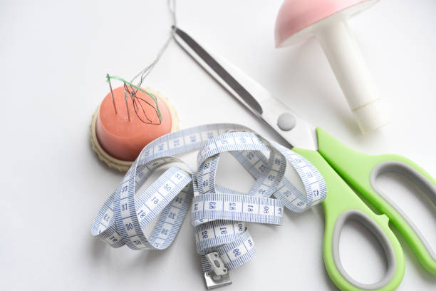 Sewing scissors, measuring tape and thread with a needle. Sewing kit.