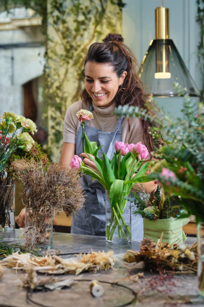istock Woman composing flower bouquet and smiling 2149143148