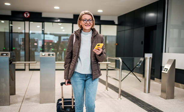 istock Mature woman passenger using phone at the train station 2149144450