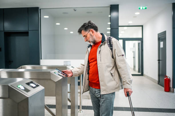 istock Mature man passing through turnstile at train station 2149144503