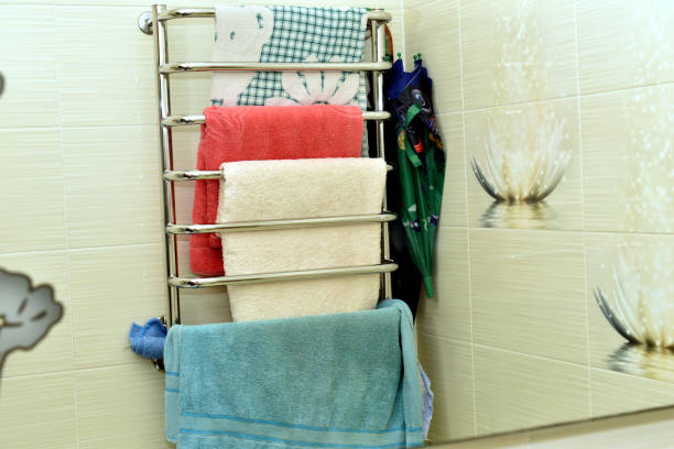 In the bathroom, towels of different colors hang on the dryer bars.