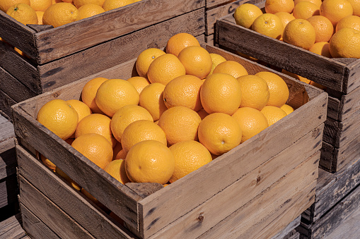 Fresh ripe orange fruits in a wooden box.